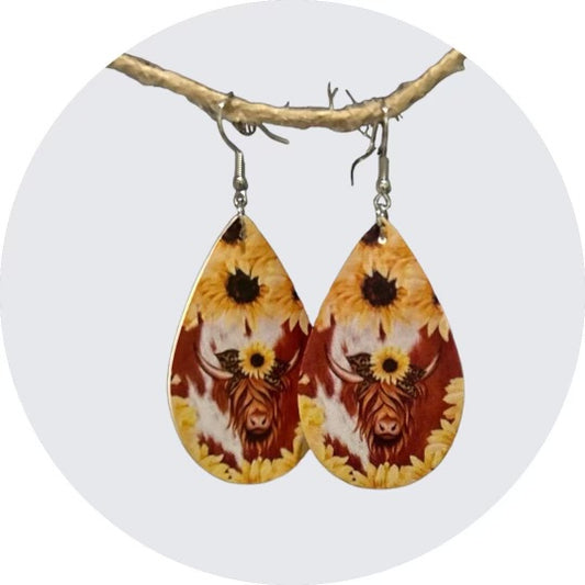 Rustic Elegance: Highlander Cow Earrings Surrounded by Sunflowers