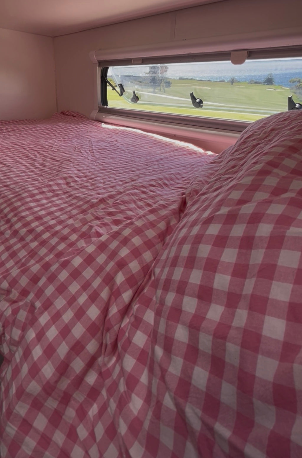 Blush Retreat 300TC pink gingham zip caravan bunk bedding set inside caravan with ocean view